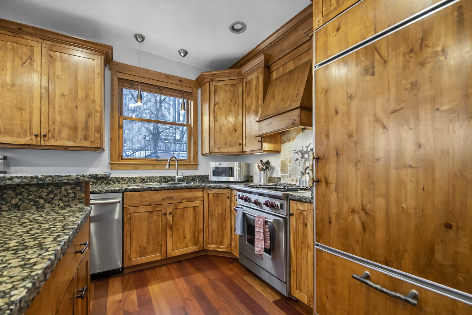 Whip up a meal in the fully equipped kitchen featuring warm wood cabinetry and sleek stainless steel appliances. The granite countertops and recessed lighting offer both style and functionality.