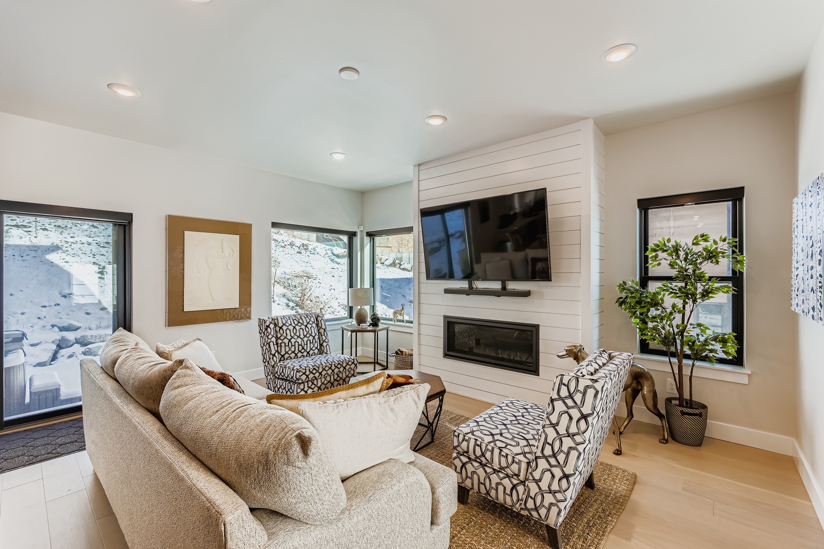 Settle into this bright, cozy living room with soft seating, a warm fireplace, and natural light streaming through large windows. Perfect for your downtime after exploring the area.