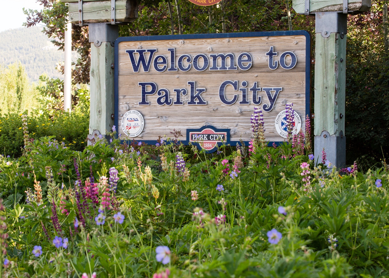 Welcome to Park City sign marks your arrival at this charming mountain destination surrounded by colorful wildflowers.