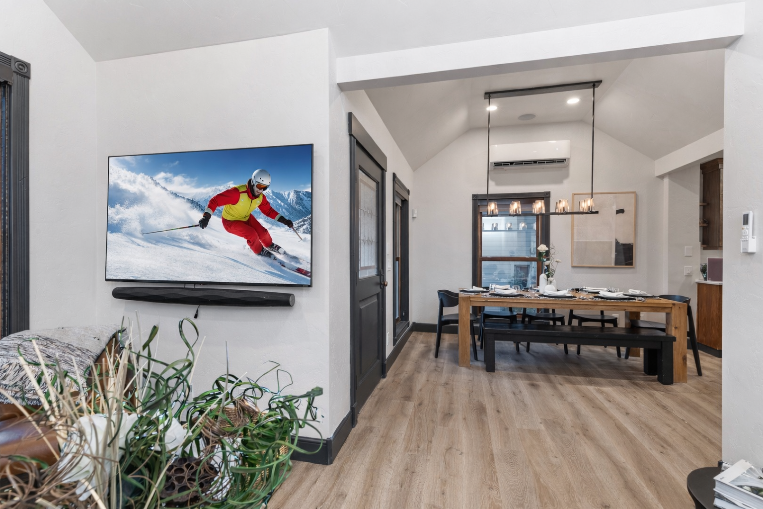 Unwind in the bright, vaulted living room with a spacious sectional, modern decor, and charming views into the chef's kitchen. The perfect cozy spot to relax.