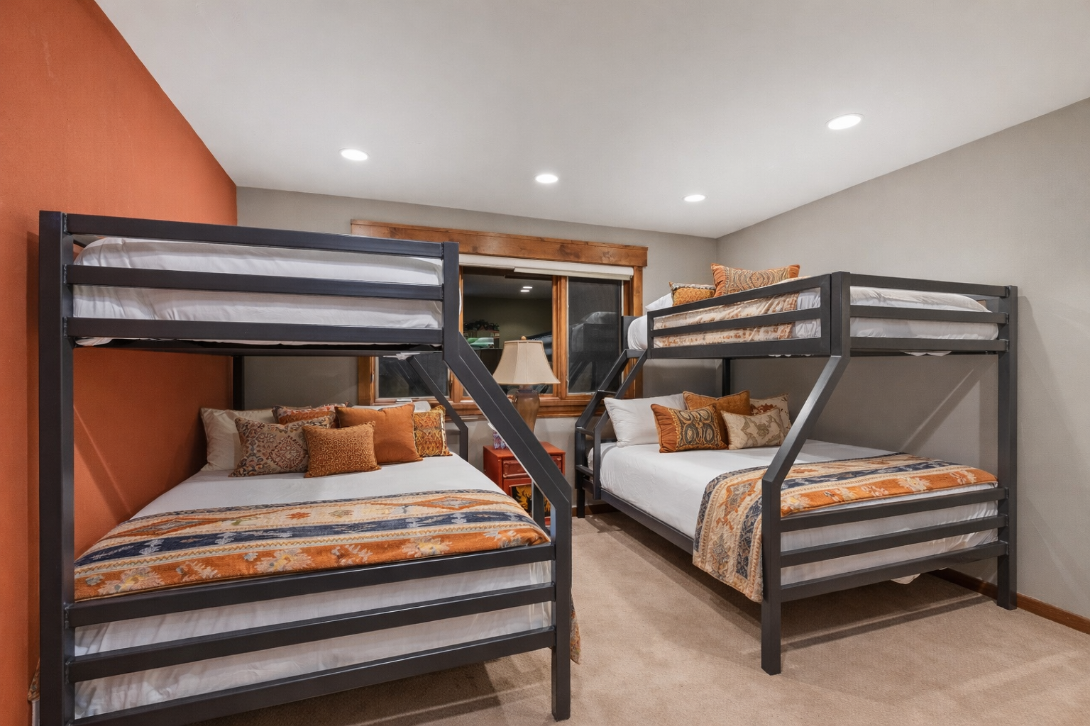 Cozy bunk beds with warm orange accents create perfect sleeping quarters for your group adventure.