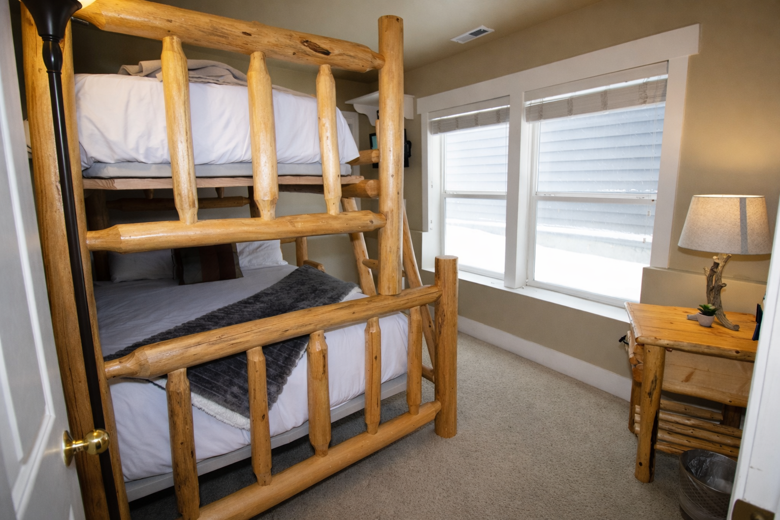 Perfect for families, this bunk room features a sturdy, hand-crafted log bed with a twin over full layout. Bright, natural light and plush carpeting create a cozy, fun retreat.