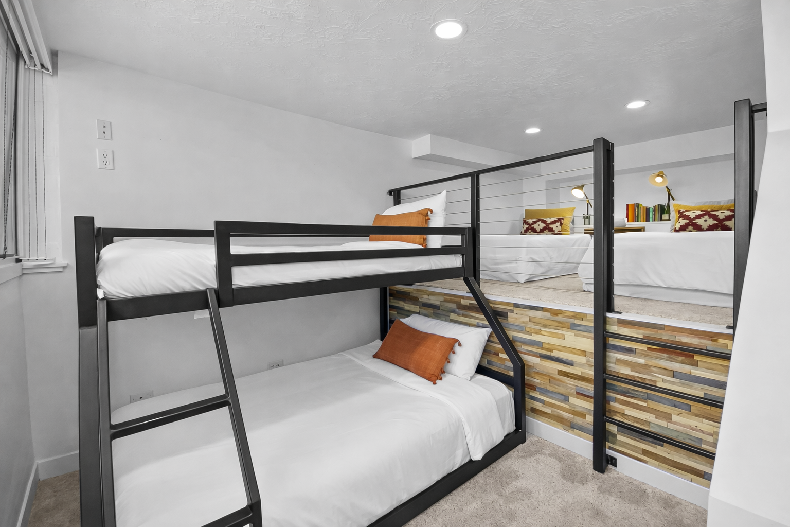 Your cozy sleeping space features modern bunk beds with plush bedding and warm orange accents for restful nights.