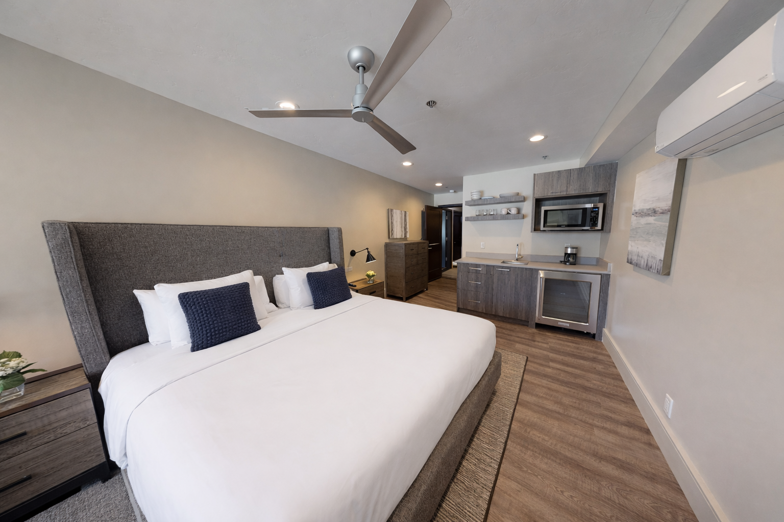 Relax in your modern studio with plush bedding, sleek kitchenette, and thoughtful amenities for a perfect stay.