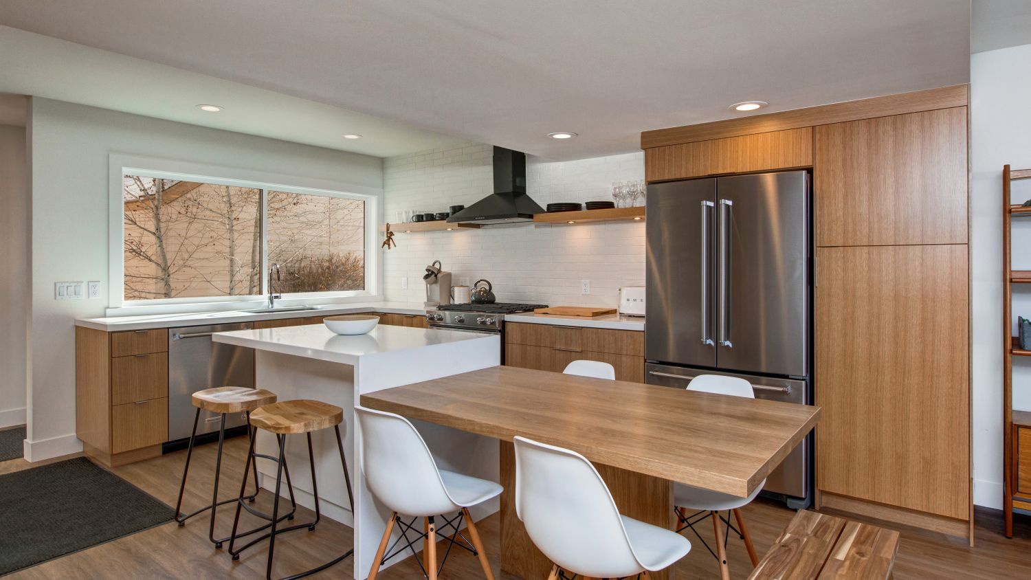 Your modern kitchen combines warm wood cabinetry with sleek stainless appliances, creating an inviting space where meal prep meets relaxation at the island seating.