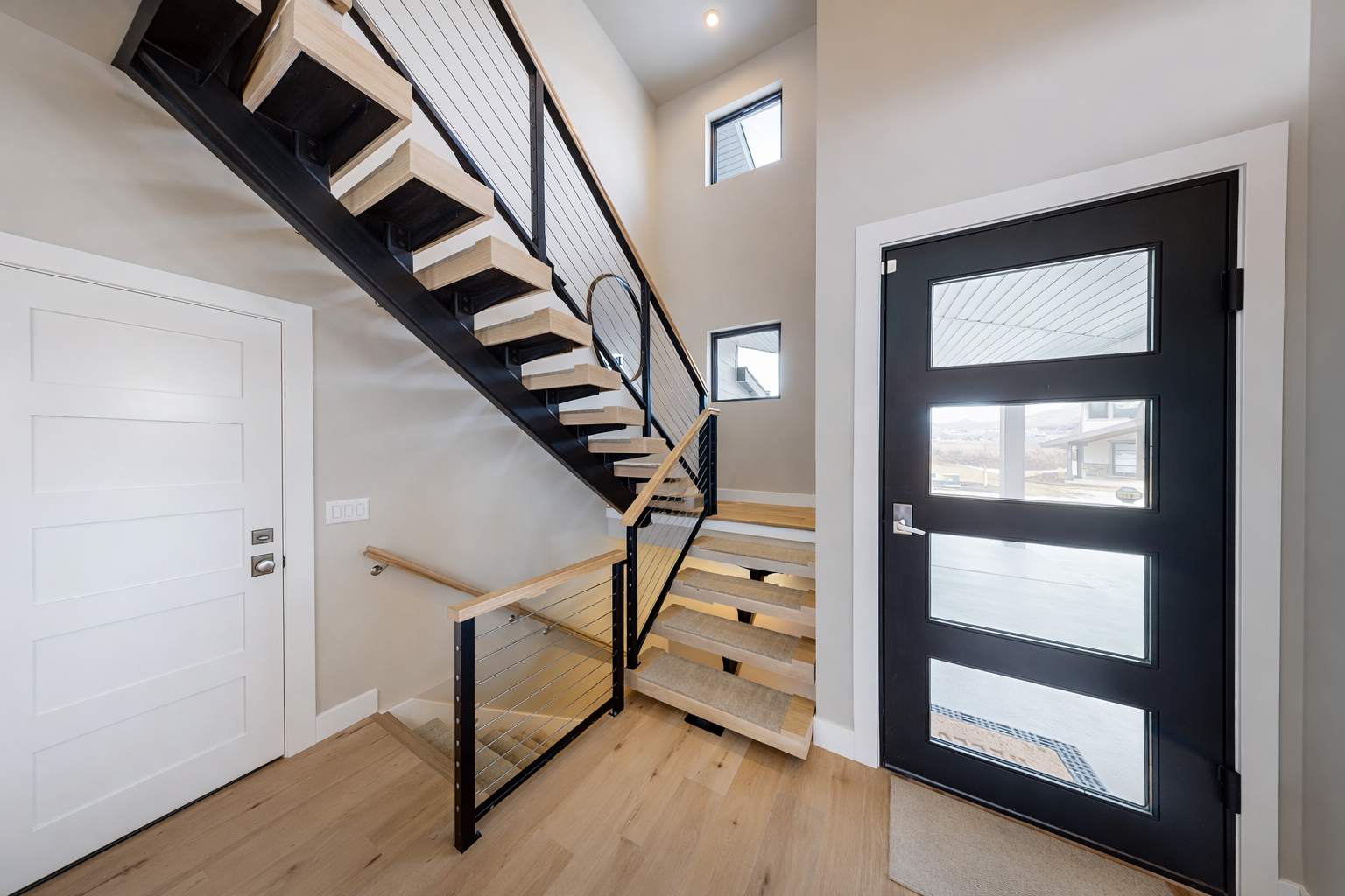 Step into your modern retreat featuring striking floating stairs and natural light streaming through sleek windows.