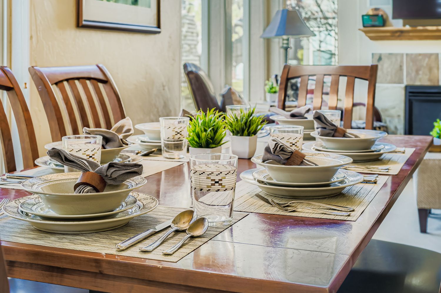 Gather around this beautifully set dining table where your meals become memorable moments with elegant place settings and fresh greenery centerpiece