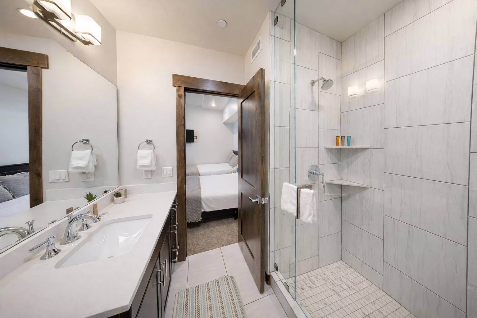 Refresh in this bright ensuite bathroom featuring a sleek glass-enclosed shower and a large vanity with ample counter space. It’s a clean, modern retreat conveniently located just off the bedroom.