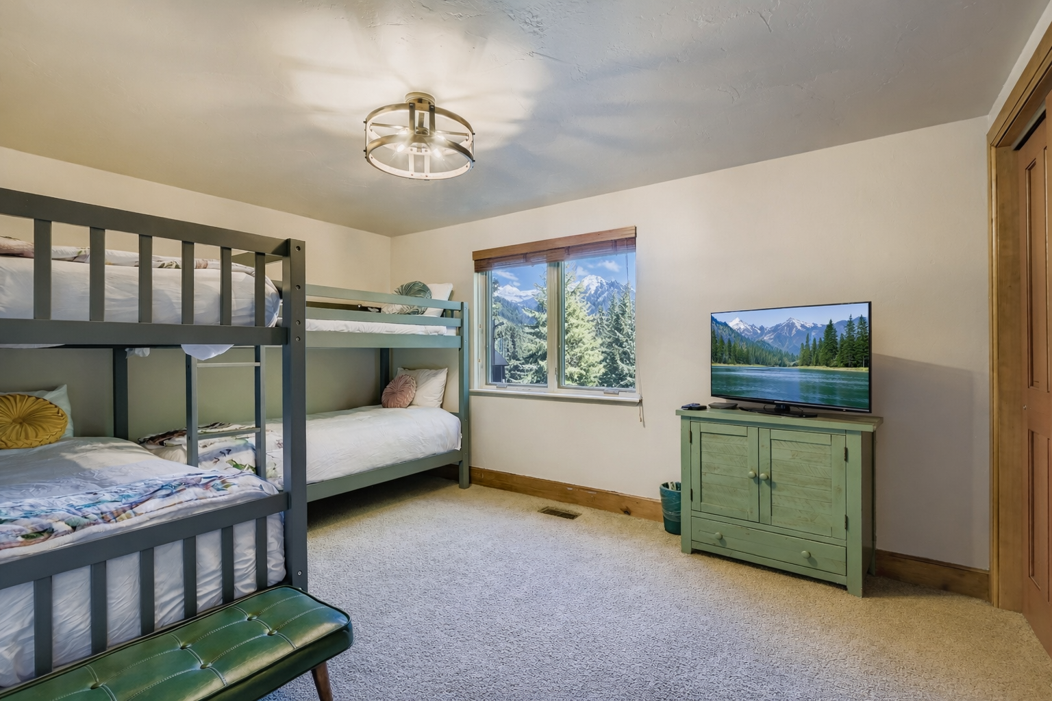 Sleep soundly in this fun bunk room! With two sets of comfortable bunk beds, a TV, and a cheerful green dresser, it's the perfect cozy spot for a great group stay.