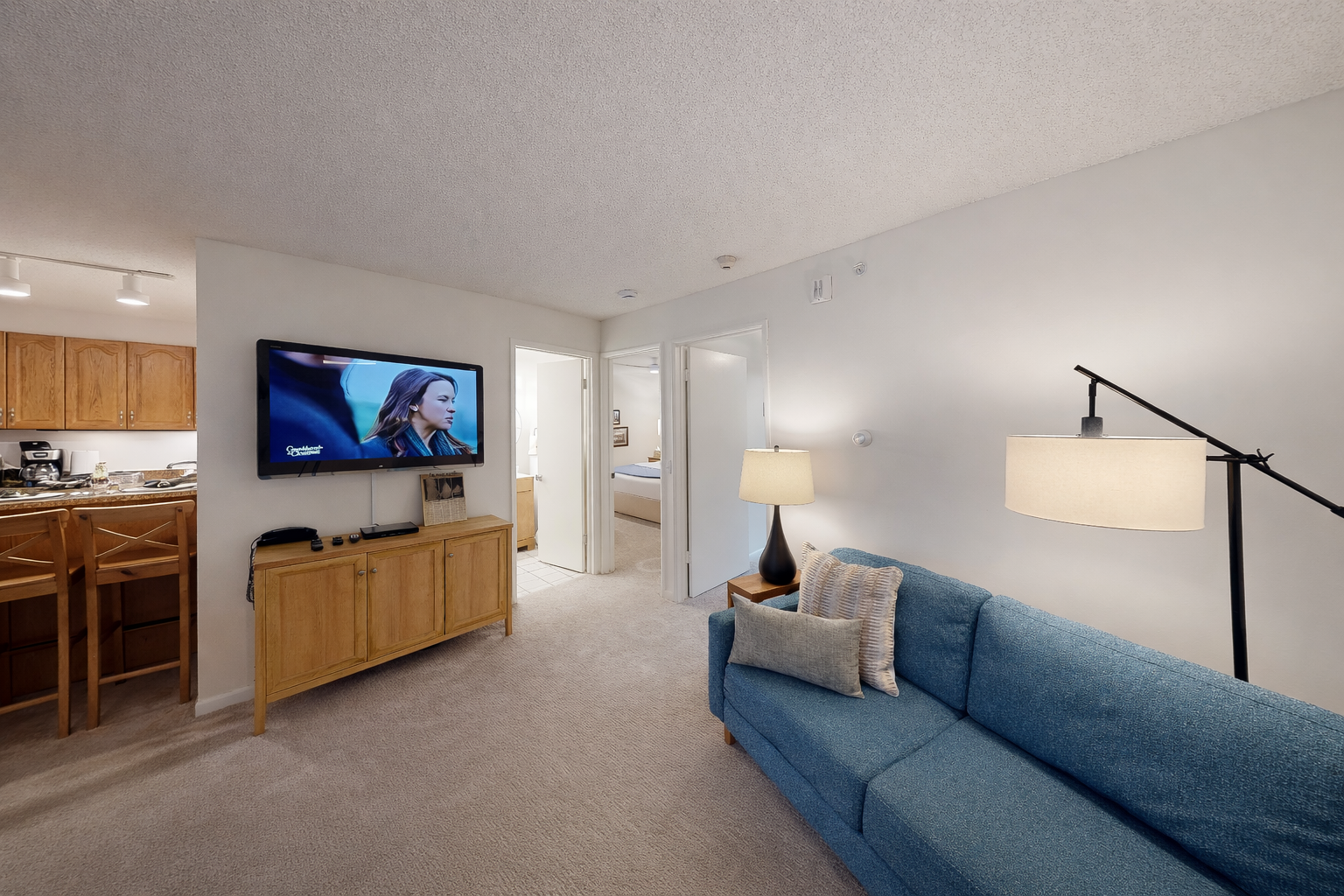 Relax in your spacious living room with plush seating, modern kitchen, and entertainment center—your perfect home away from home awaits.