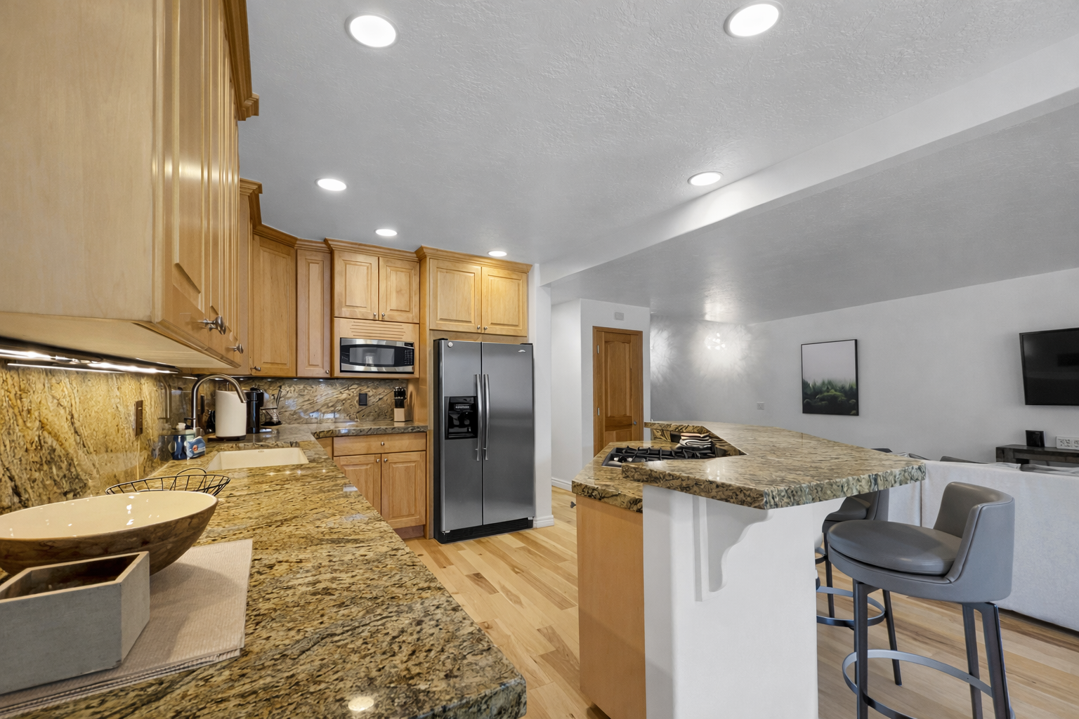 This fully equipped kitchen features stunning granite countertops, modern stainless steel appliances, and a convenient island, perfect for preparing meals during your stay.