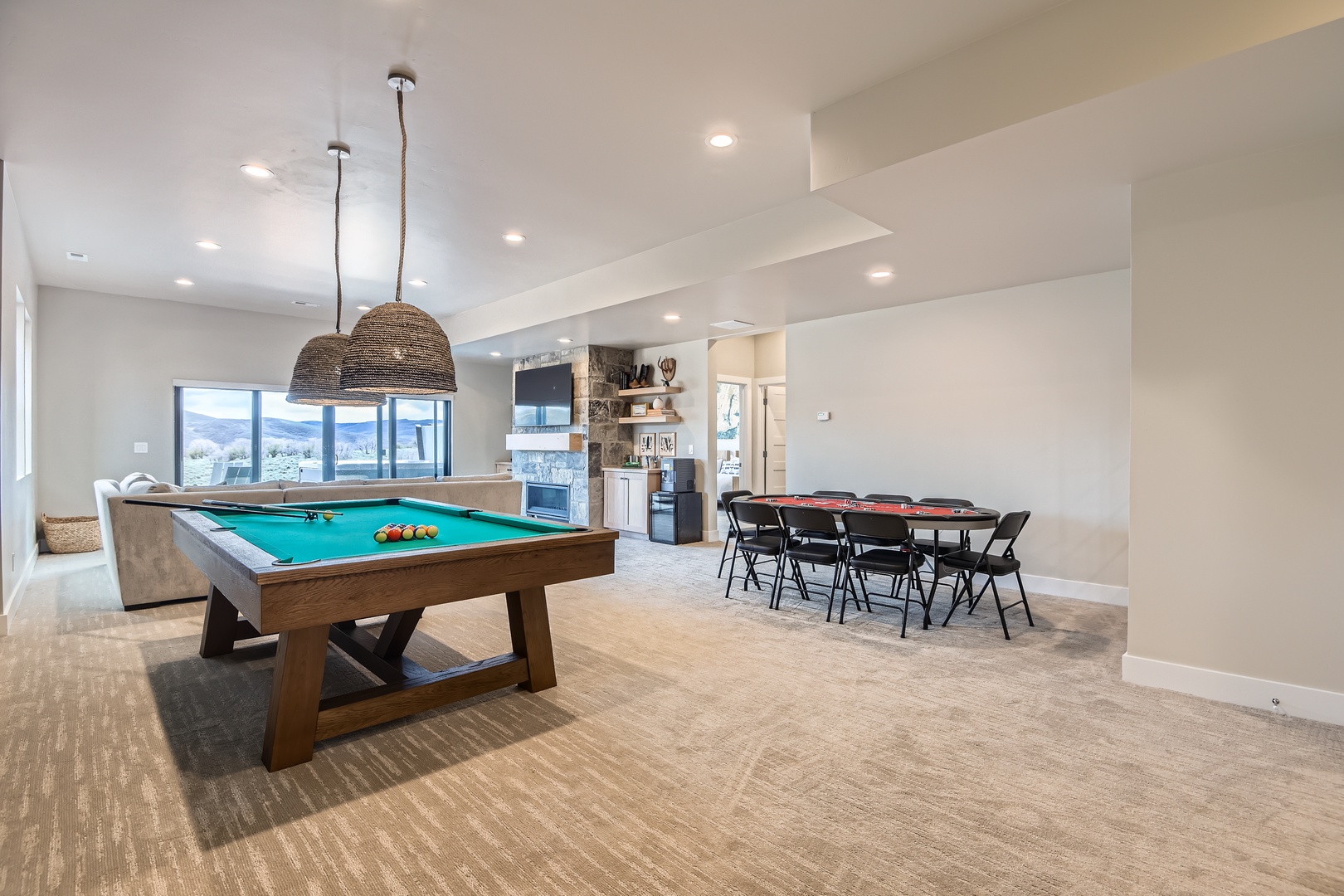 Gather around the pool table or share meals at the dining table while soaking in natural light and mountain views from this inviting open-concept space.