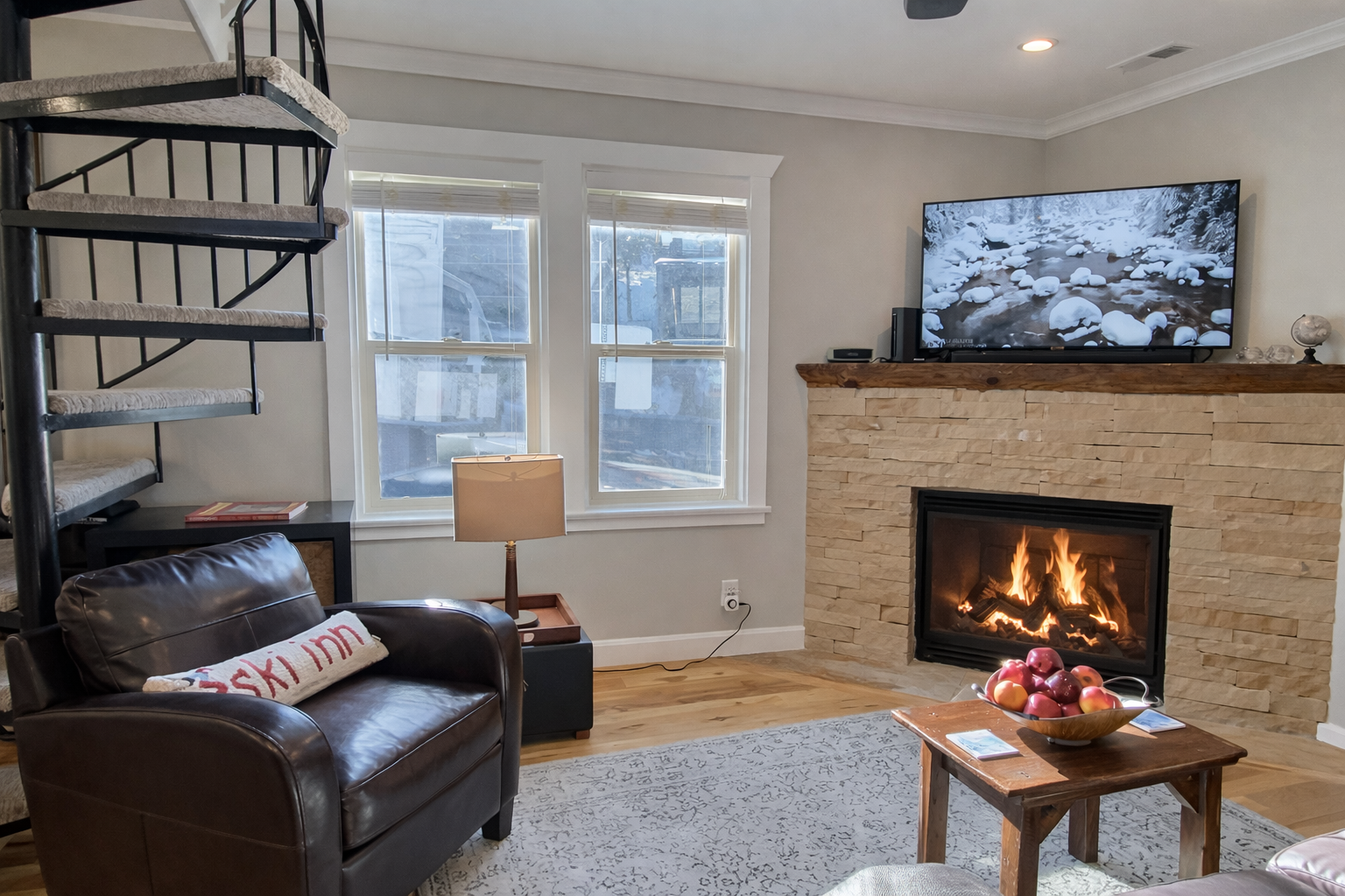 Unwind by the warm stone fireplace in this cozy living space with a comfortable leather armchair and TV. Perfect for your Park City getaway.