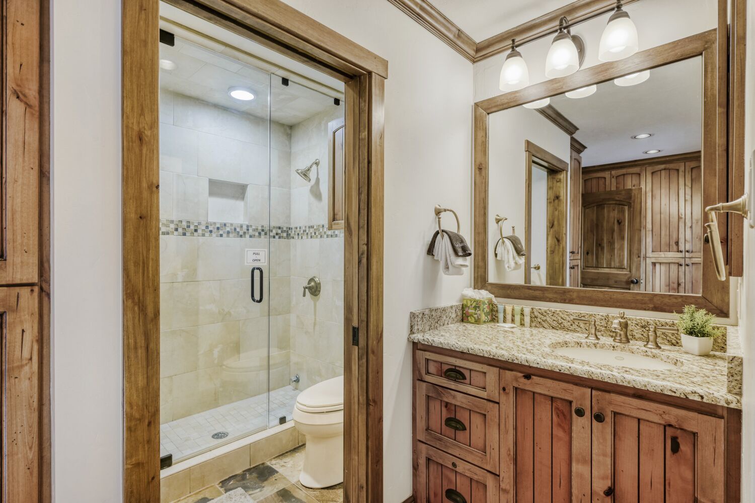 Unwind in your spa-like bathroom with elegant granite counters, rustic wood vanity, and refreshing glass-enclosed shower.