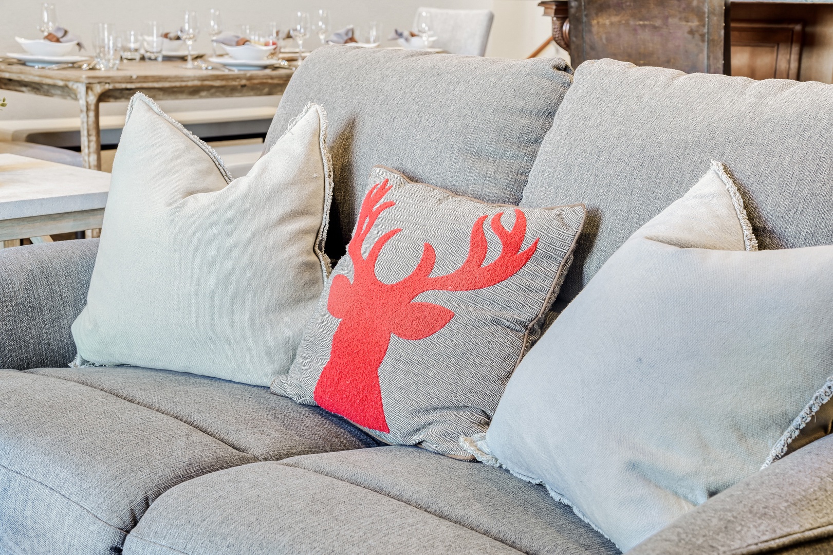 Sink into plush gray cushions with charming coral deer pillow—your perfect spot to unwind after exploring.