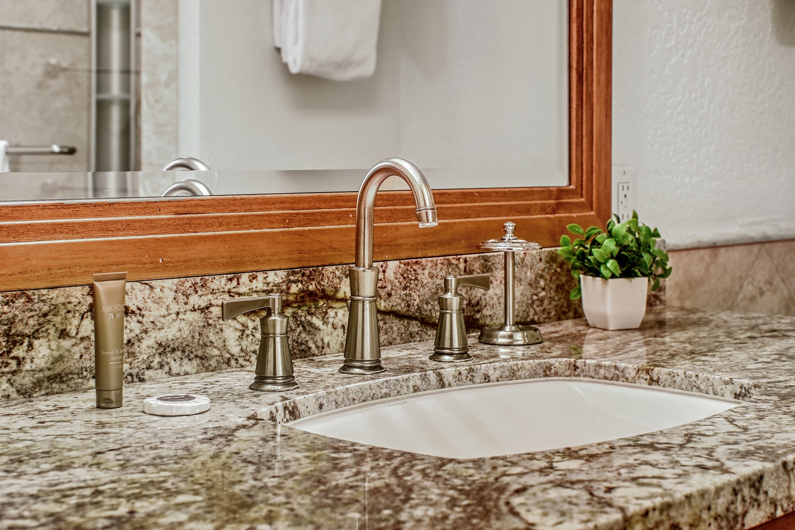 Elegant granite countertops and polished fixtures create your perfect prep space, complete with thoughtful touches like fresh greenery.