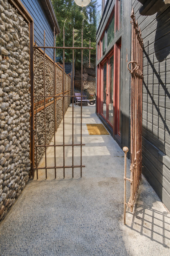 Unique rustic entrance combining stone walls and a metal gate. A charming, secure path welcomes you to your mountain getaway.