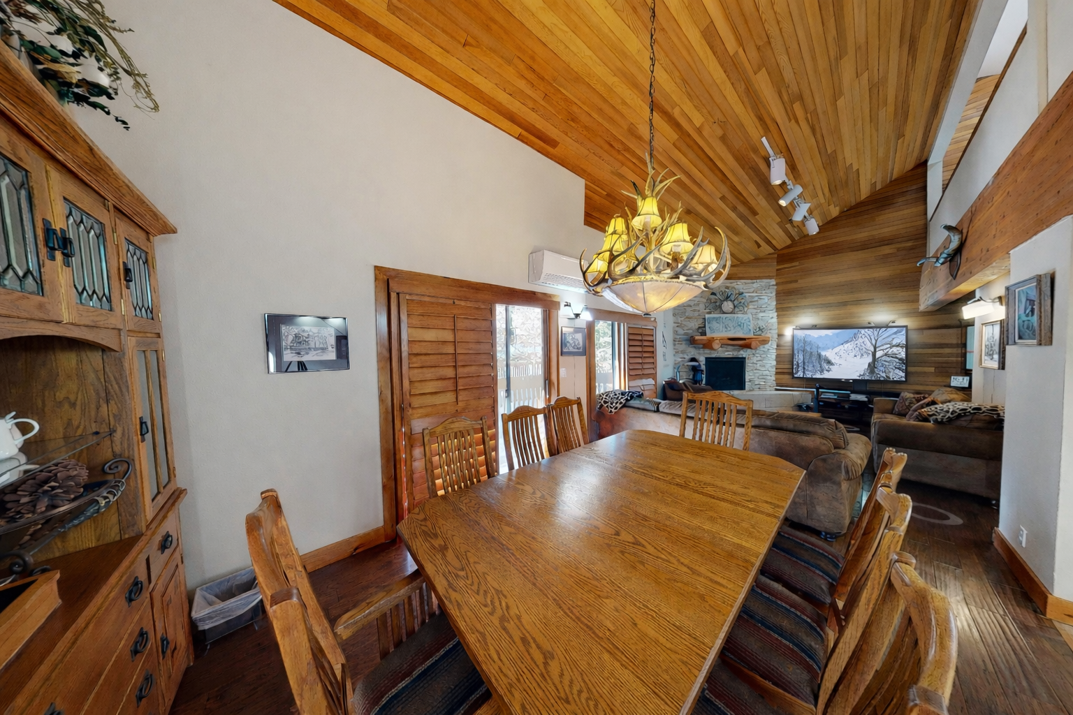 Gather around your spacious dining table beneath warm wood beams and natural light streaming through windows.