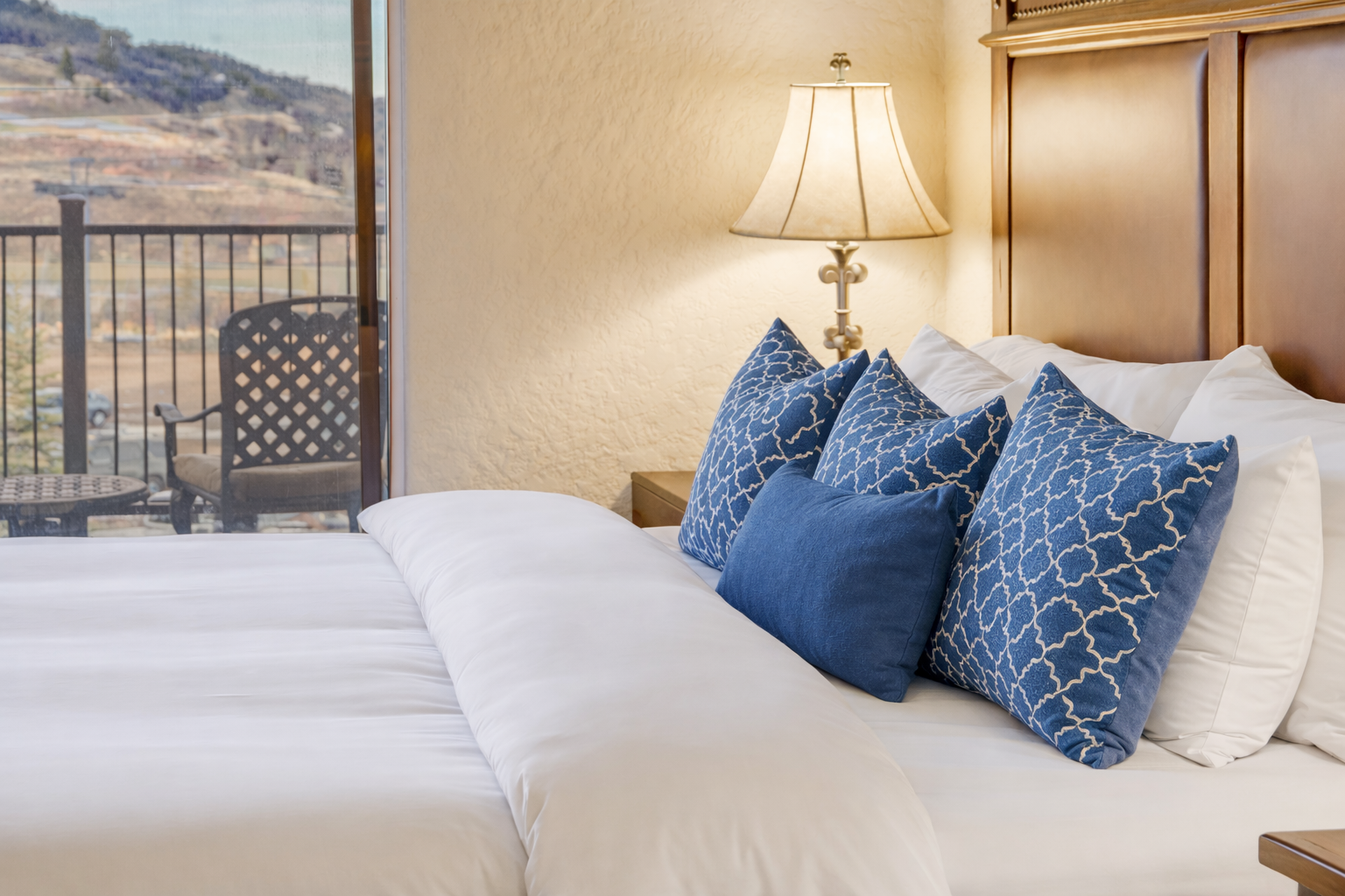 Relax in this spacious master suite featuring a king bed and handcrafted wood furniture. A serene retreat designed for ultimate comfort and a restful night's sleep.