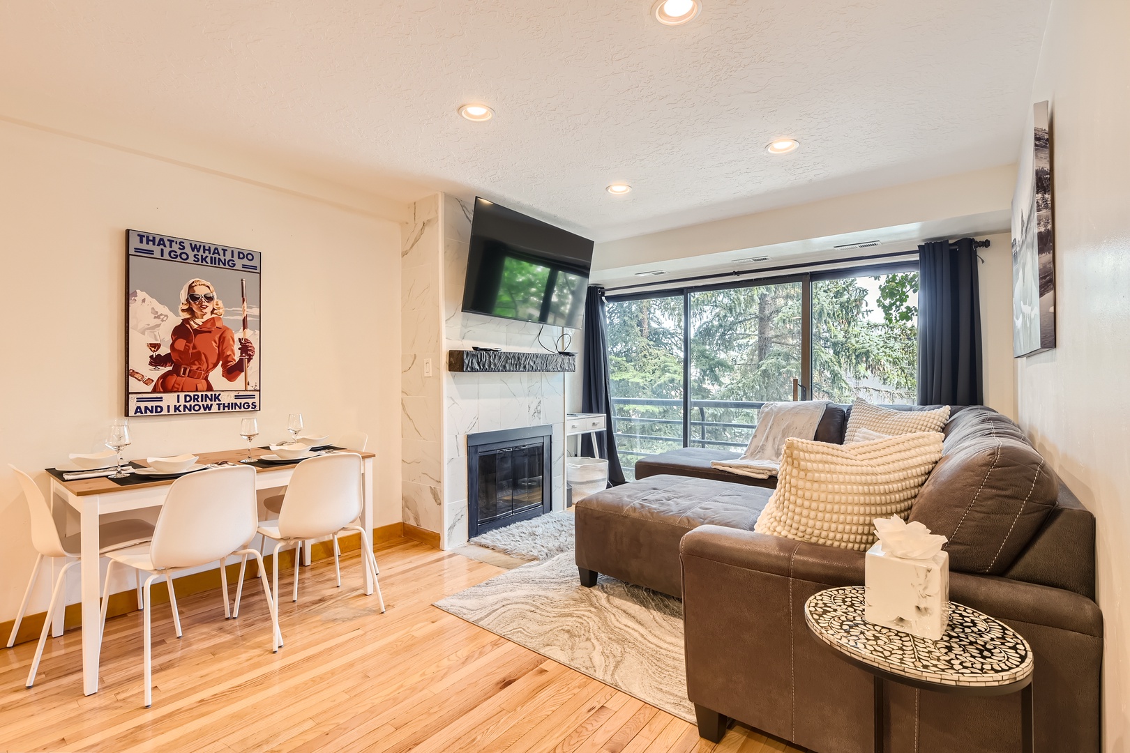 Relax on the cozy leather sofa in your inviting living space, where natural light pours through large windows and a warm fireplace creates the perfect ambiance for unwinding after your adventures.