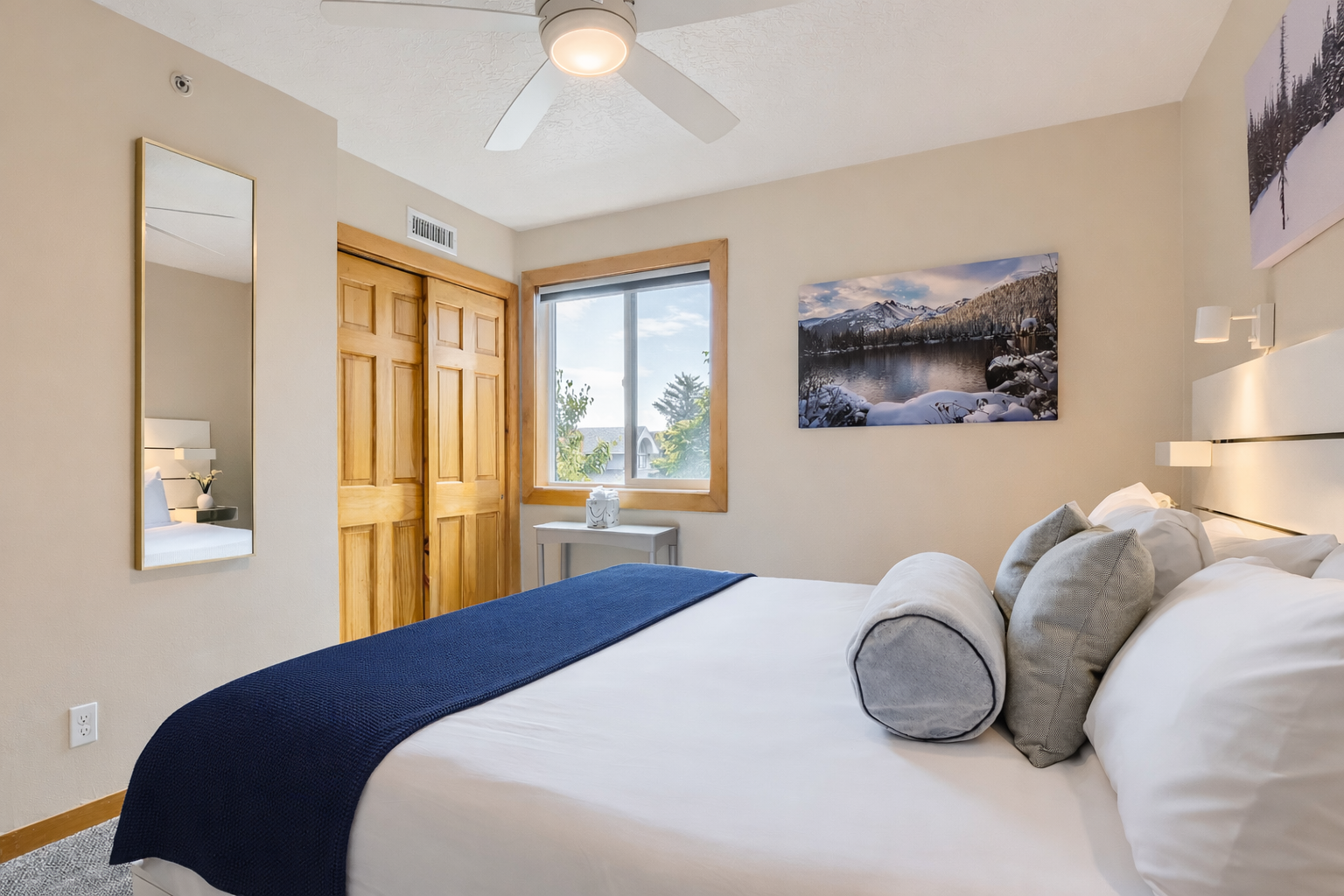 Peaceful primary bedroom with a comfortable king-size bed, ceiling fan, and lovely artwork. A tranquil retreat for a restful stay in the mountains.