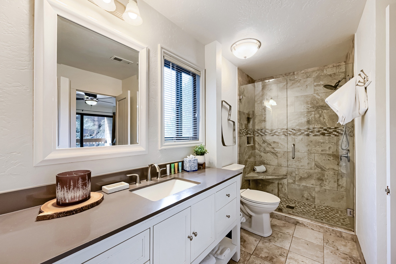 Elegantly designed with luxurious marble tile and natural light, this spacious bathroom features a walk-in shower perfect for refreshing mountain mornings and peaceful retreats after adventures.