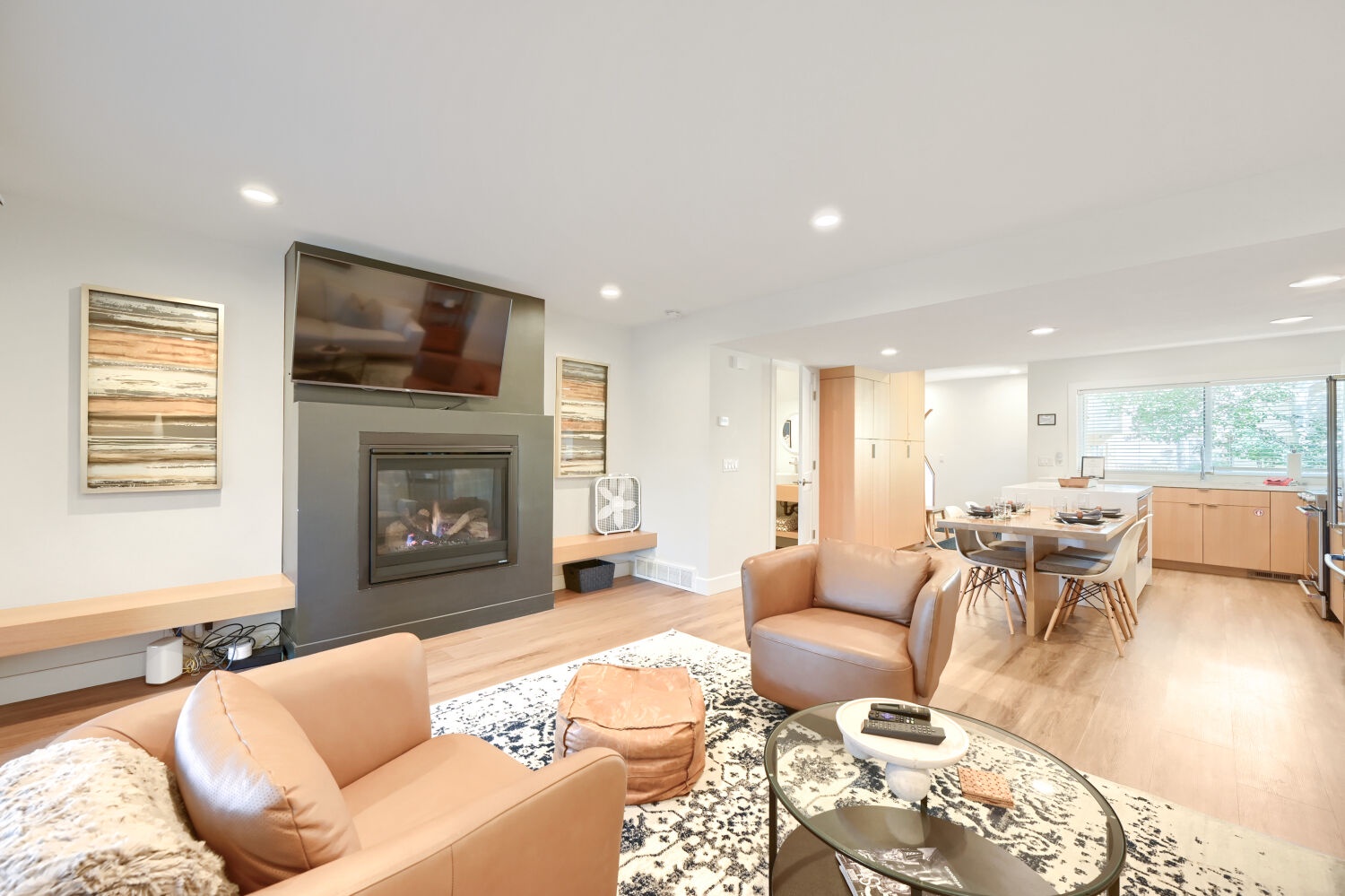 Relax in your modern open-concept living space with sleek fireplace and stylish furnishings flowing seamlessly into the fully-equipped kitchen.