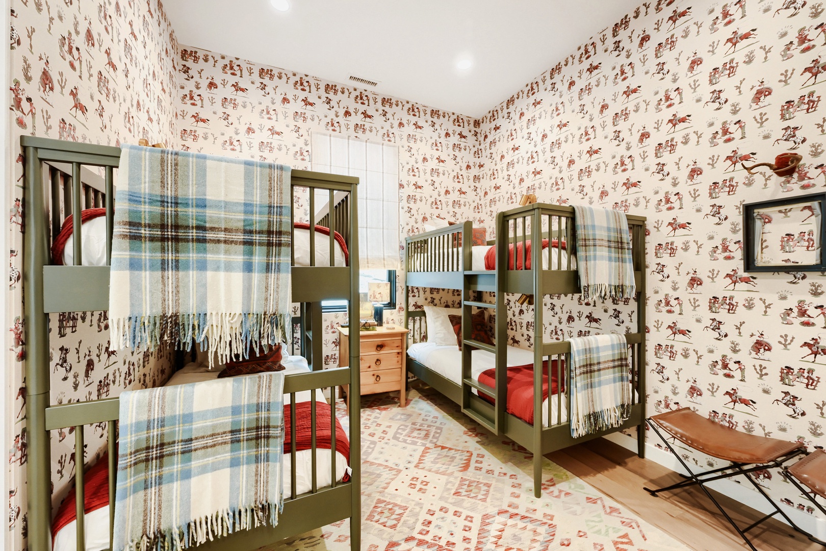 Drift off surrounded by nostalgic wallpaper in this charming bunk room—your cozy retreat after days of adventure.