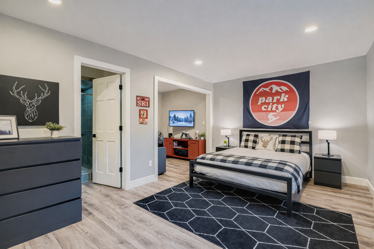 Retreat to this cozy bedroom featuring a comfortable queen and twin bunks and TV. The Park City decor creates a perfect mountain getaway.