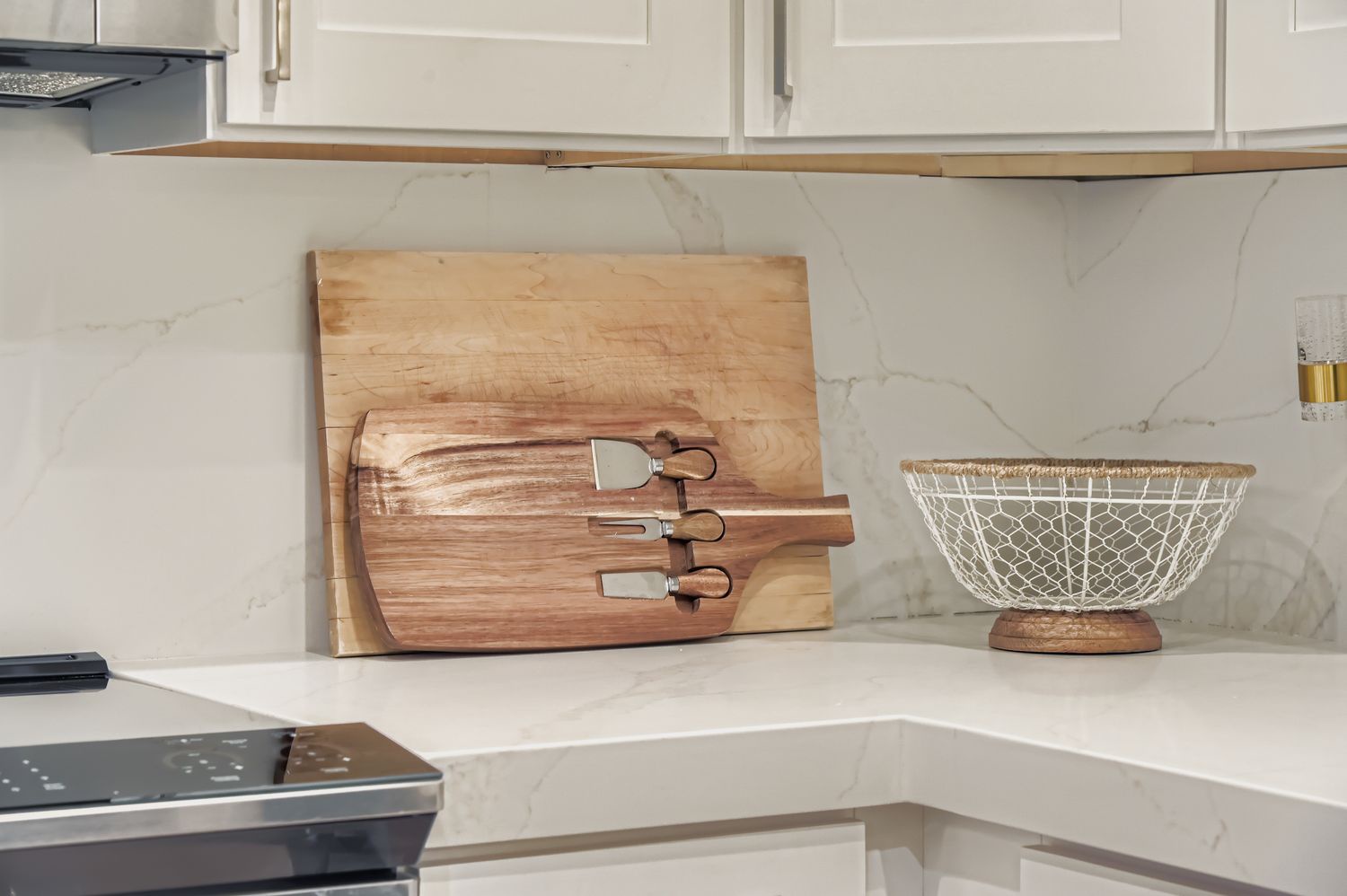 Your stylish kitchen features elegant marble countertops and premium white cabinetry, thoughtfully equipped with quality utensils and serving pieces for your culinary adventures.