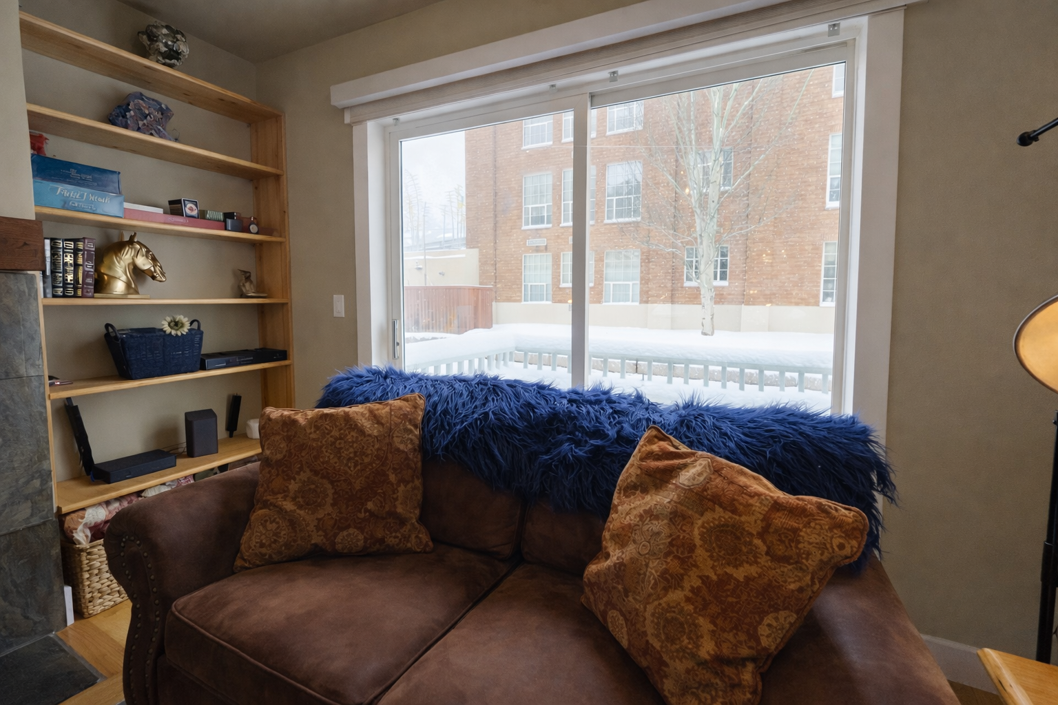Sink into this cozy reading nook with plush cushions and built-in shelving, where winter views create the perfect backdrop for relaxation.