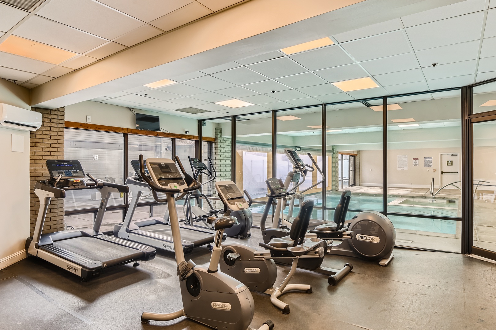 Stay energized in your bright fitness center with cardio equipment overlooking the inviting pool—perfect for balanced wellness during your stay.