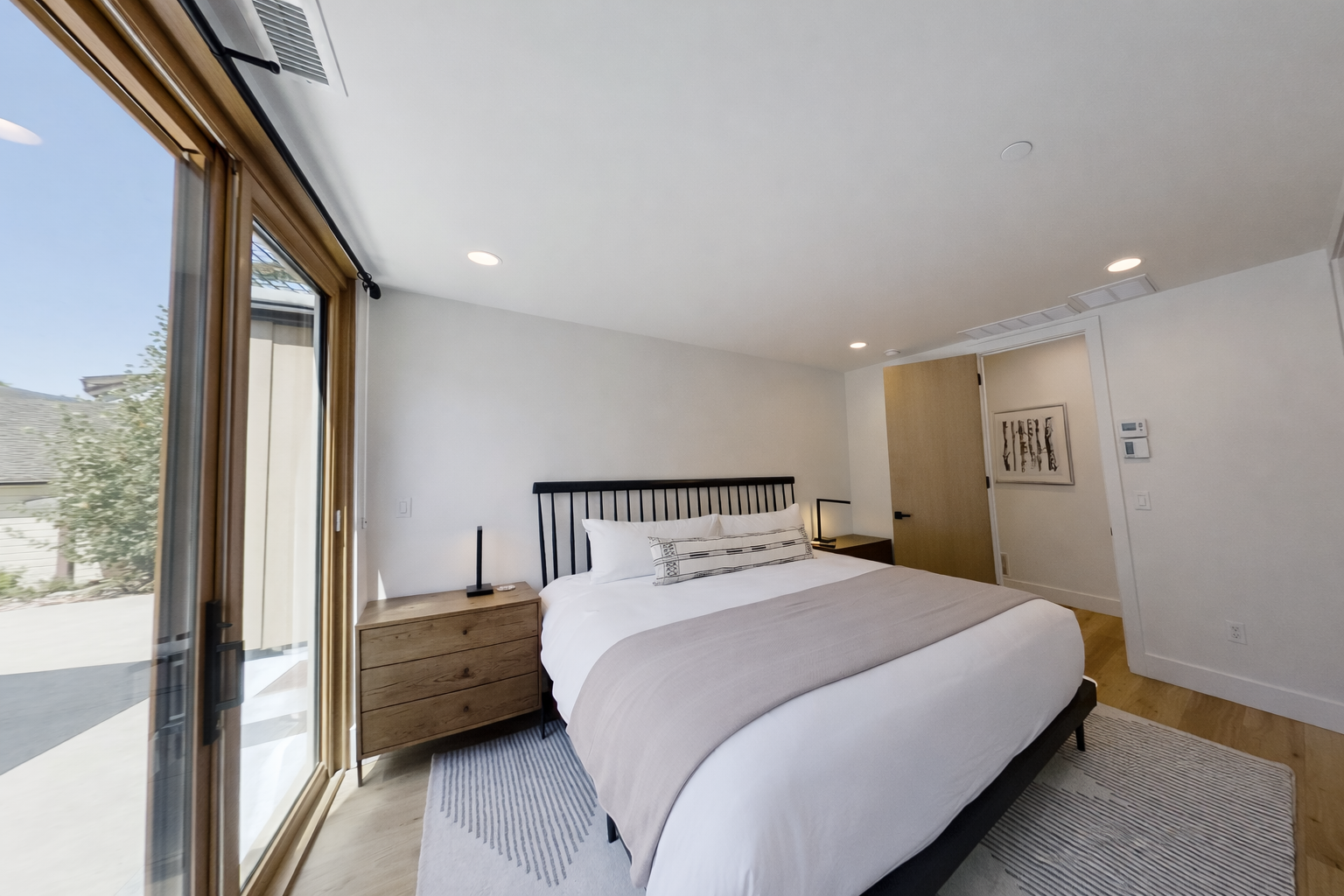 Retreat to the stylish master suite featuring a large king-size bed, natural light, and modern decor.