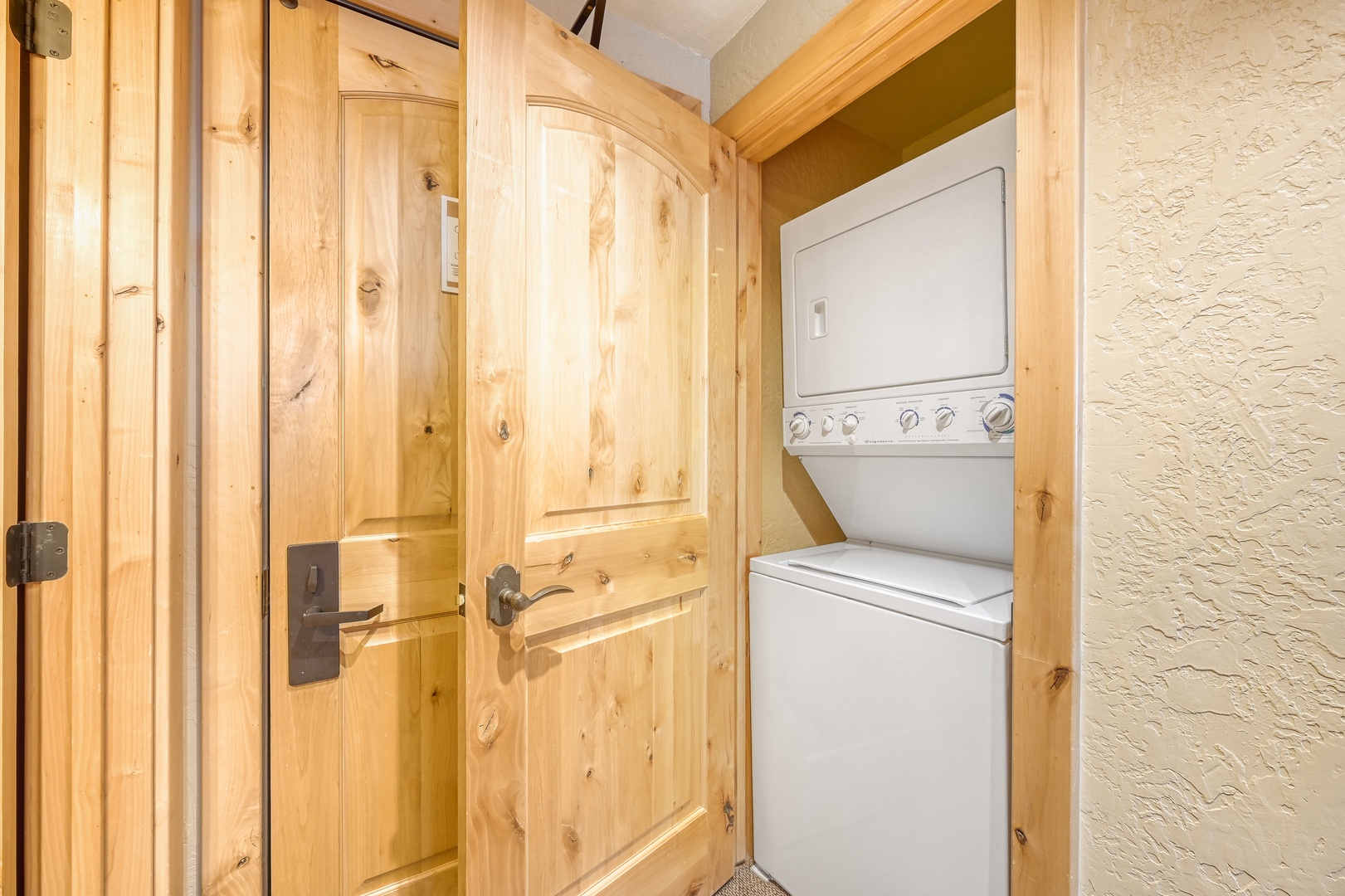 Your private laundry area features a convenient washer-dryer combo tucked behind rustic wooden doors, making it easy to pack light.