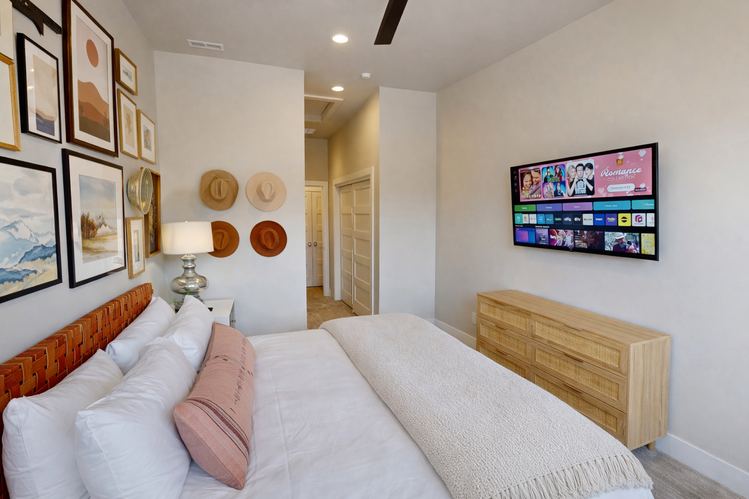 Sink into plush bedding while enjoying your favorite shows on the wall-mounted TV in this stylishly decorated bedroom.
