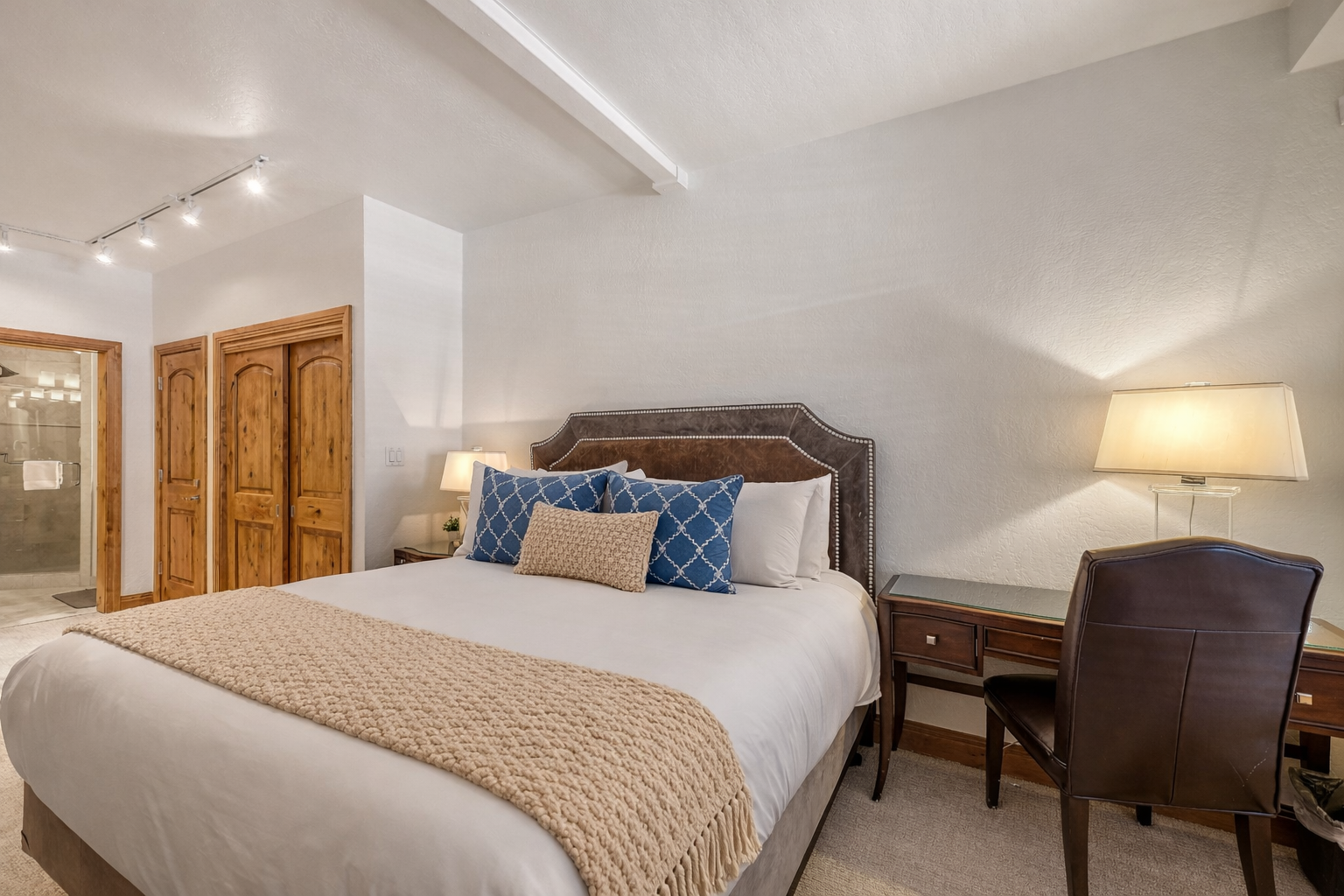 Relax in this peaceful bedroom retreat featuring a plush king bed, stylish decor, and warm lighting. A tranquil oasis for your stay.