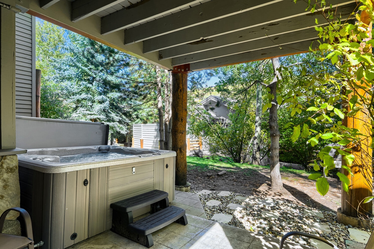 Step outside to your private covered patio and settle into the hot tub, where towering trees and a peaceful garden setting create your own secluded retreat.
