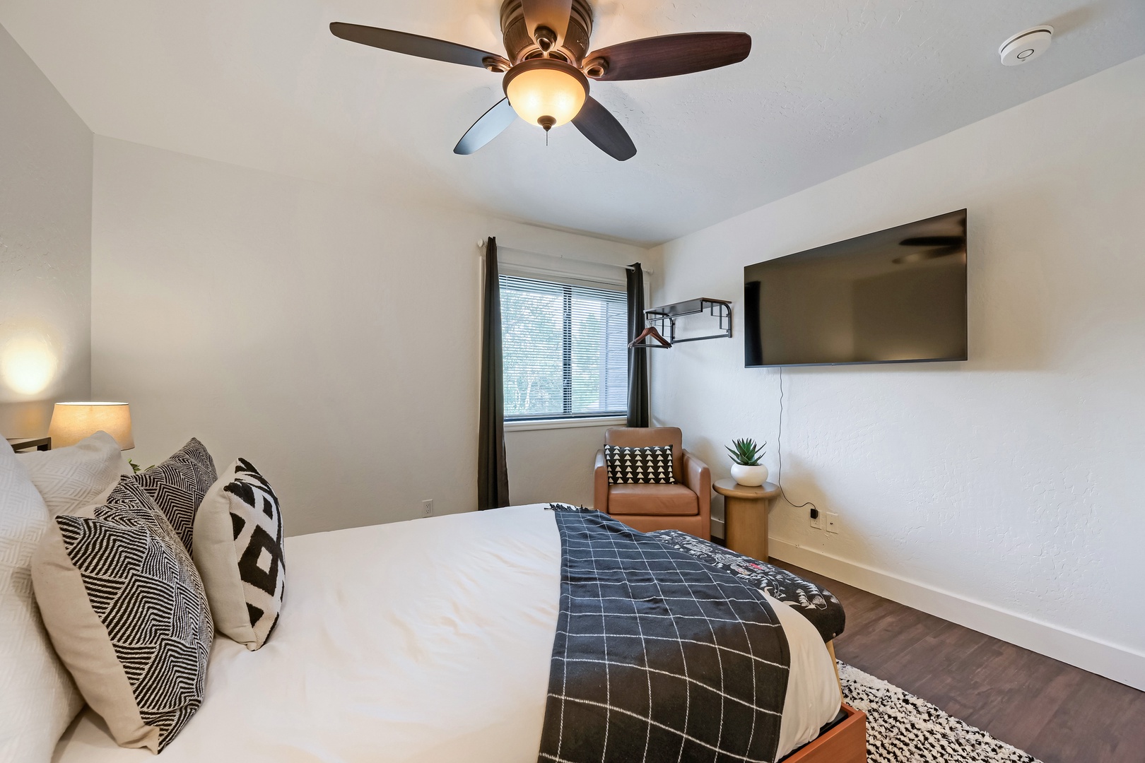 Slip into crisp linens under a gentle ceiling fan, with natural light streaming through your window and modern touches creating a serene retreat.