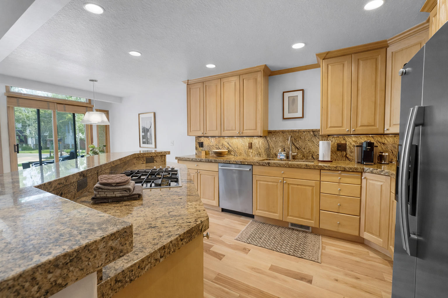This fully equipped kitchen features stunning granite countertops, modern stainless steel appliances, and a convenient island, perfect for preparing meals during your stay.