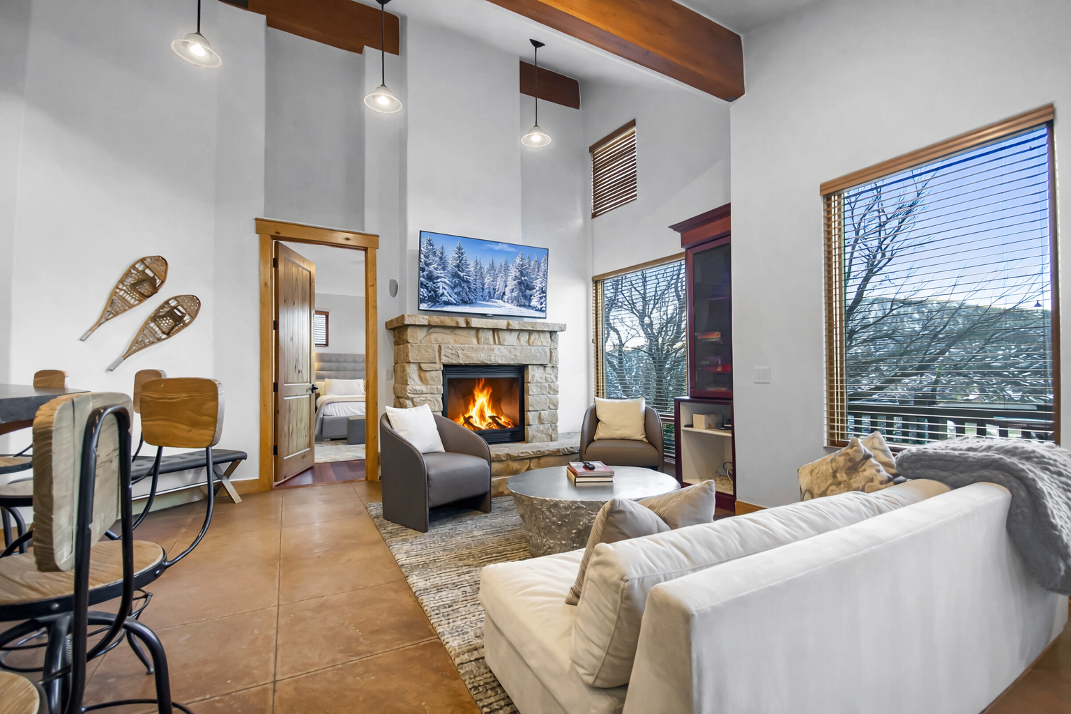 Cozy up in your stylish mountain retreat with soaring ceilings, crackling fireplace, and warm wood accents creating the perfect après-ski atmosphere.
