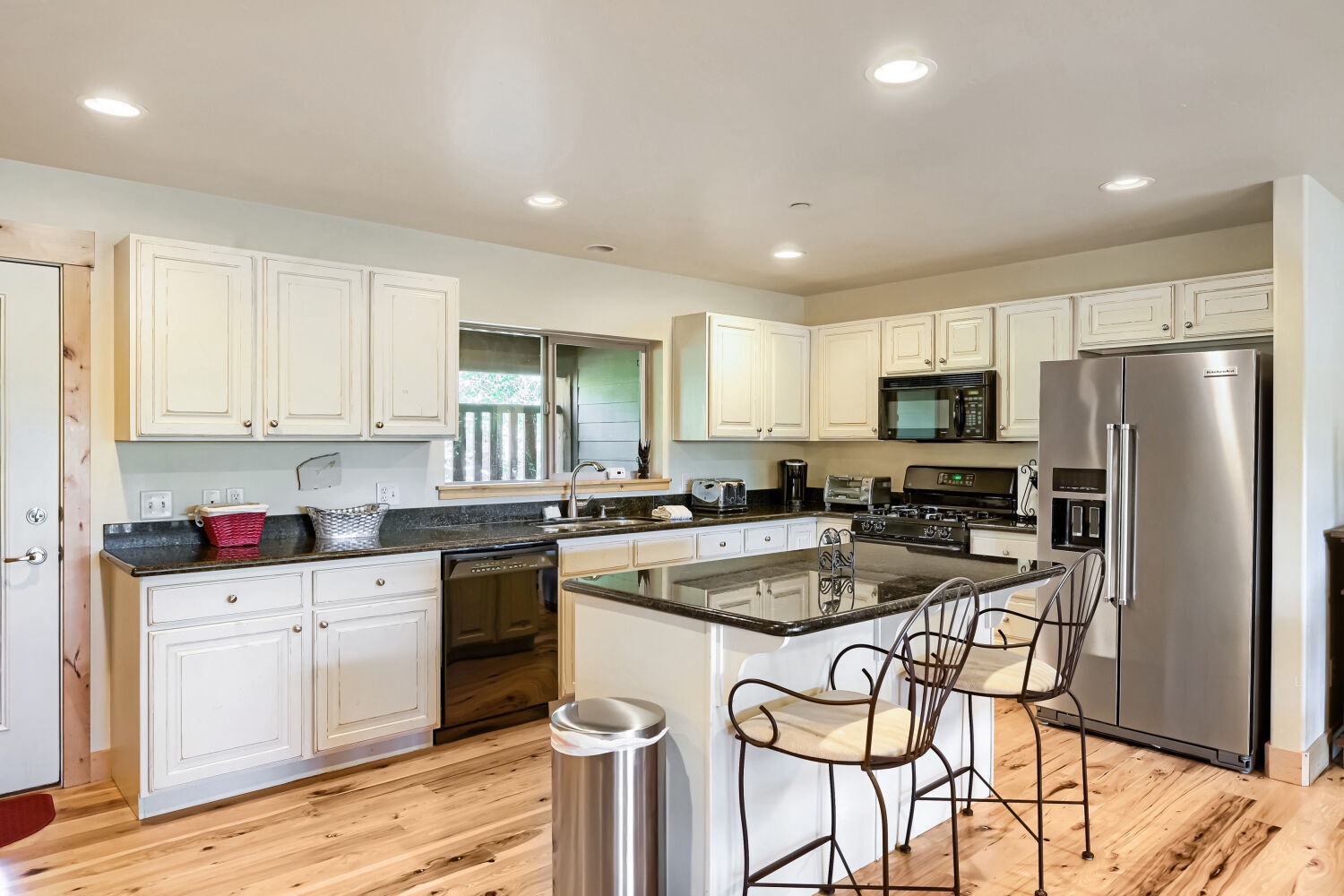 Step into your fully equipped kitchen where white cabinetry meets sleek countertops and stainless steel appliances—everything you need to whip up delicious meals during your stay.