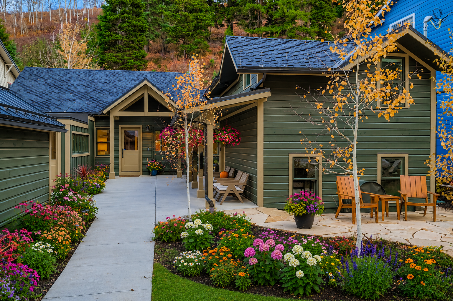 Charming mountain retreat with vibrant gardens, covered porches, and peaceful seating areas framed by colorful autumn foliage and evergreens.