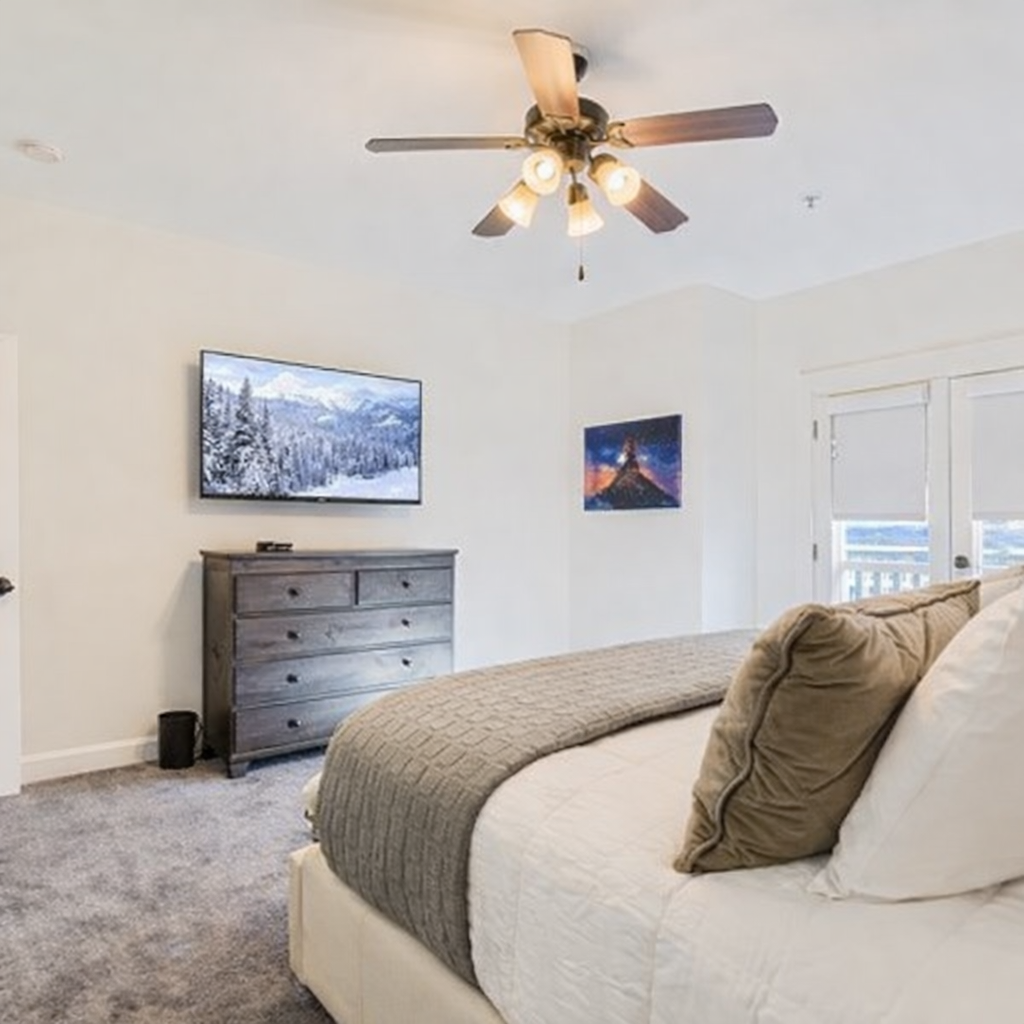 Relax in your comfortable bedroom with cozy bedding, entertainment TV, and ceiling fan to keep you cool during your stay.