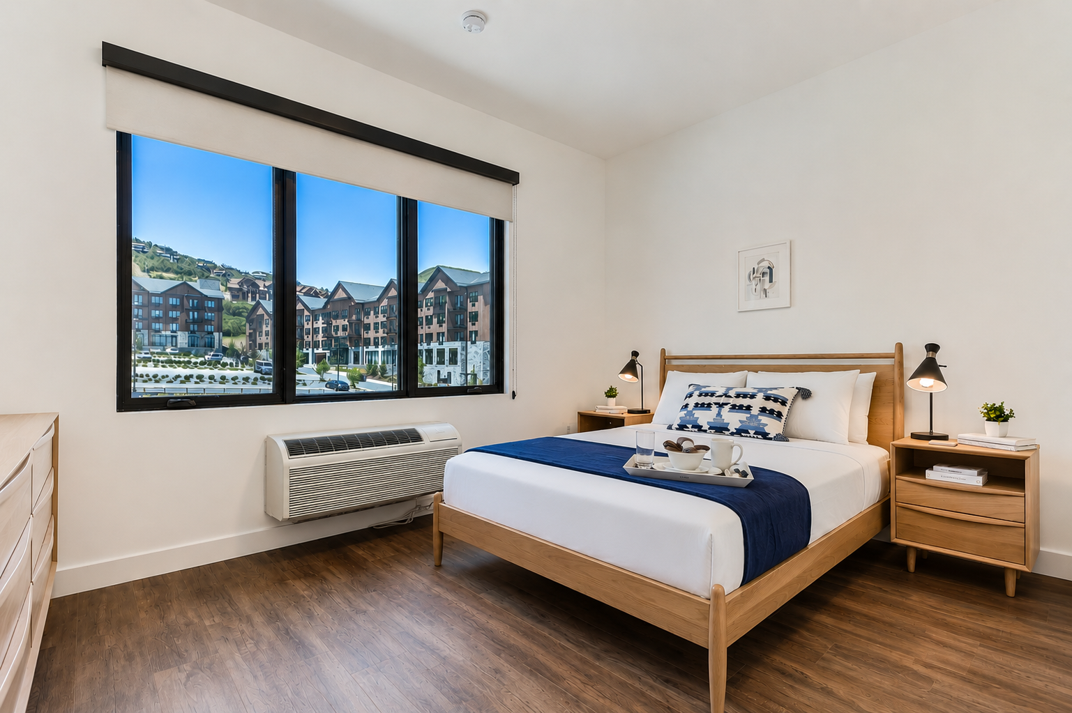 Drift into restful sleep in your bright bedroom with mid-century modern furnishings, crisp white linens, and valley views through generous windows. The climate-controlled comfort and clean design create your perfect retreat.