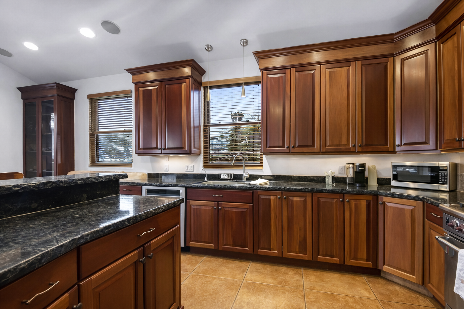 You'll love cooking in this elegant kitchen with rich wood cabinets, granite countertops, and modern appliances.