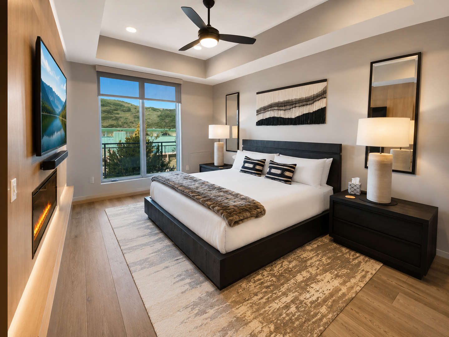 Retire to this quiet, modern bedroom featuring a comfortable bed, ceiling fan, and large windows with scenic views. It's the perfect escape after a busy day.