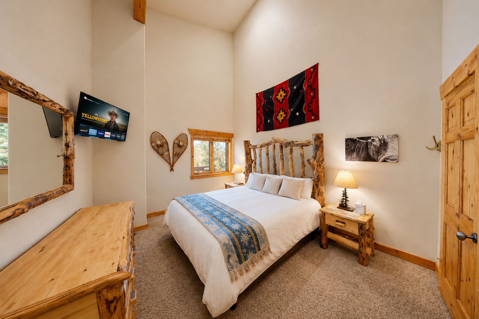 Unwind in your cozy bedroom featuring a handcrafted log bed, rustic décor, and warm southwestern touches. Enjoy your favorite shows on the wall-mounted TV after a day of adventure.