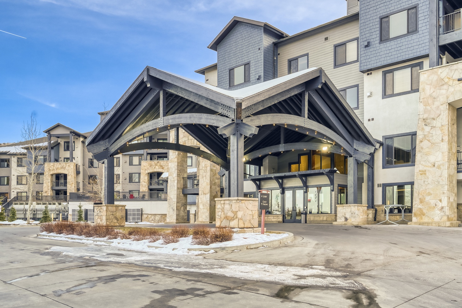 Modern property entrance with distinctive curved architecture and stone accents creates an impressive arrival experience.