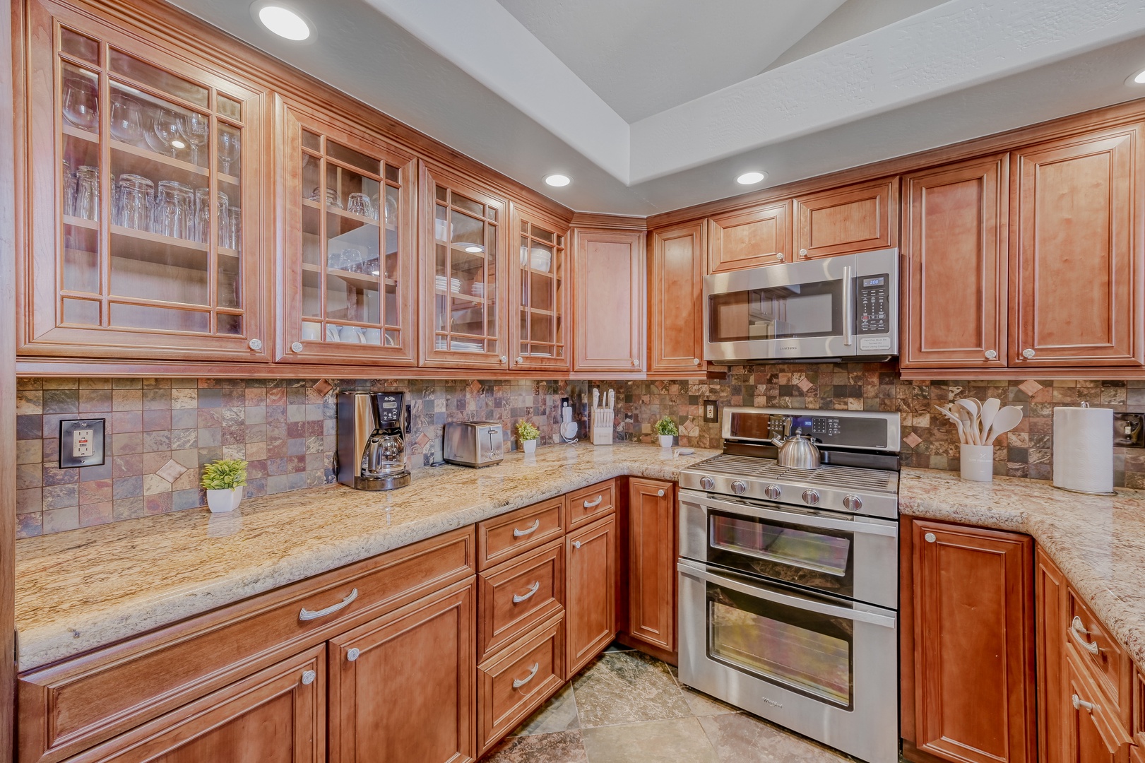 Your fully equipped gourmet kitchen features warm wood cabinets, granite counters, and stainless steel appliances for memorable meal preparation.
