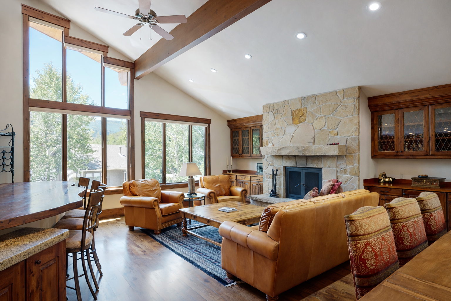Relax in our spacious living area with a vaulted wood ceiling, cozy fireplace, and stunning views of the surrounding nature.